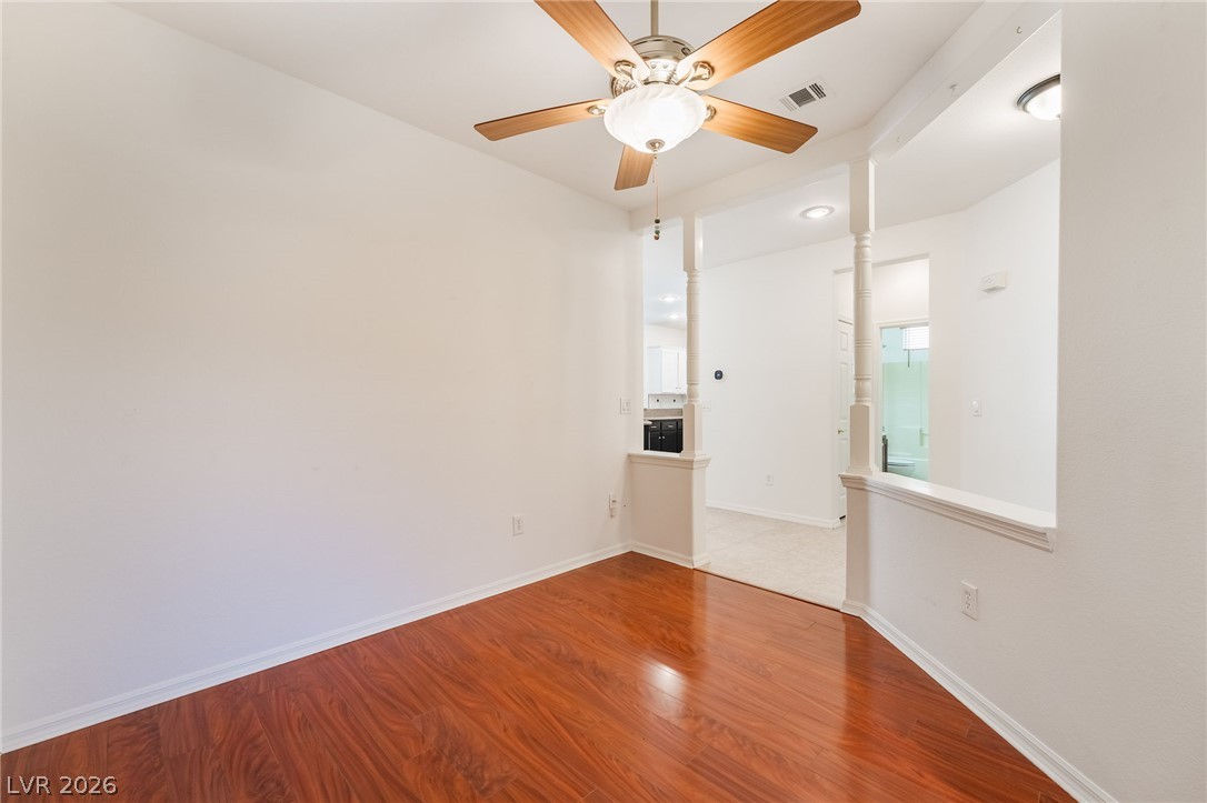5389 Progresso Street Las Vegas, NV 89135 - Photo 9 of 41 Hardwood flooring and a ceiling fan adorn this well-lit dining area, creating a comfortable gathering space.