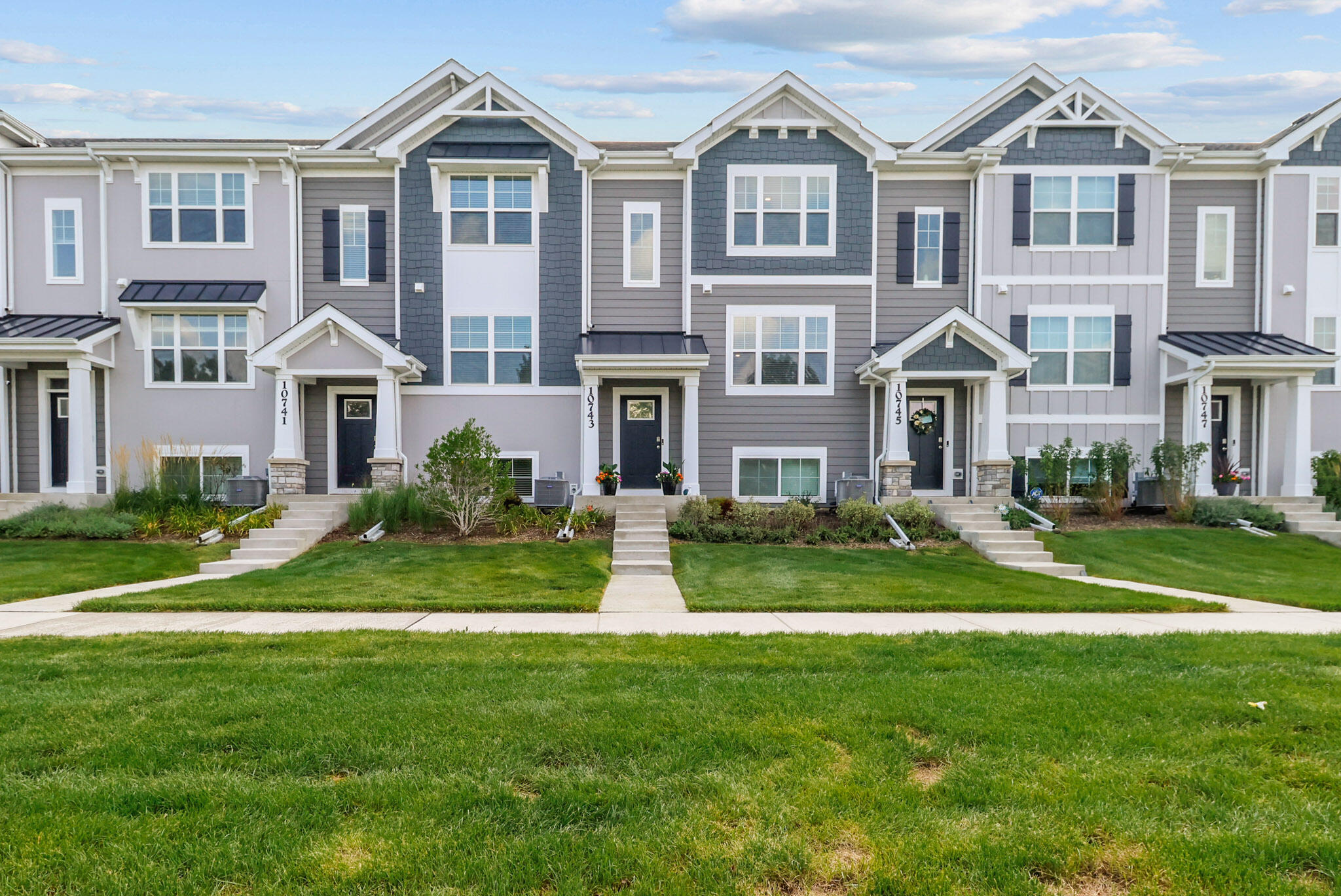 a front view of a house with a yard and large windows