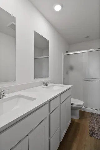 a bathroom with a granite countertop toilet a sink and a mirror