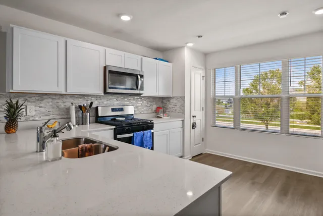 a living room with furniture a flat screen tv and kitchen view
