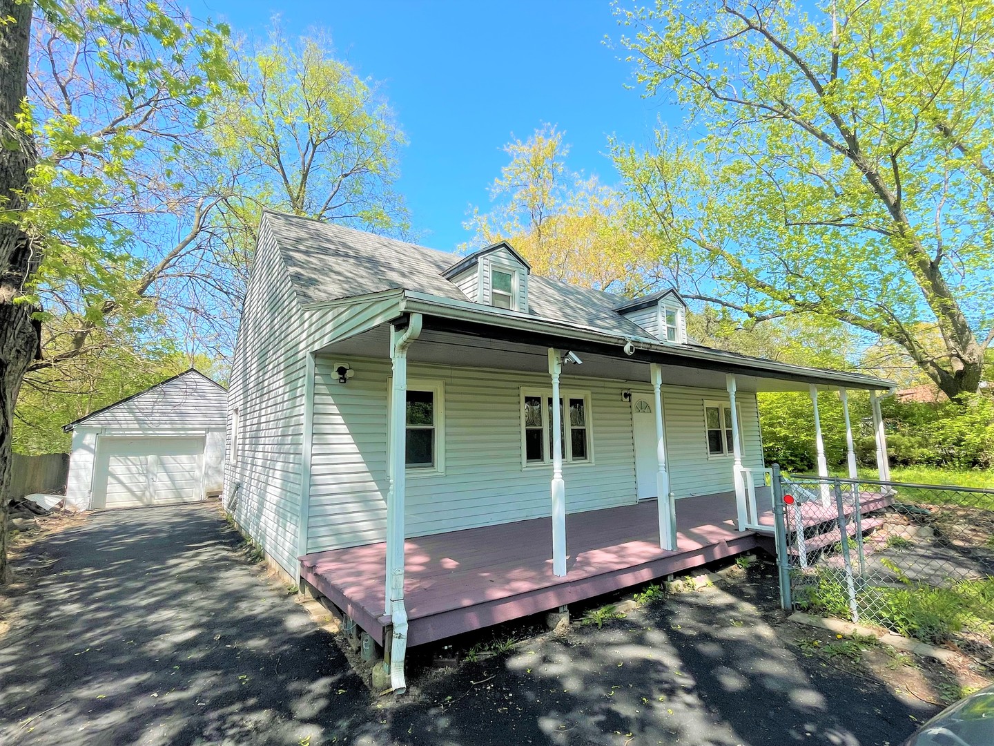 a view of a backyard with table and chairs and a large tree