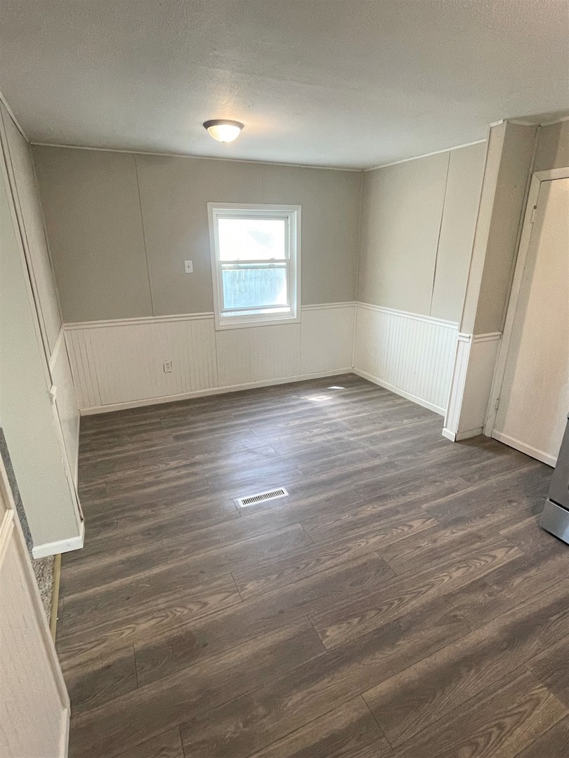 1119 New Lenox Road Joliet, IL 60433 - Photo 4 of 10 an empty room with wooden floor and windows