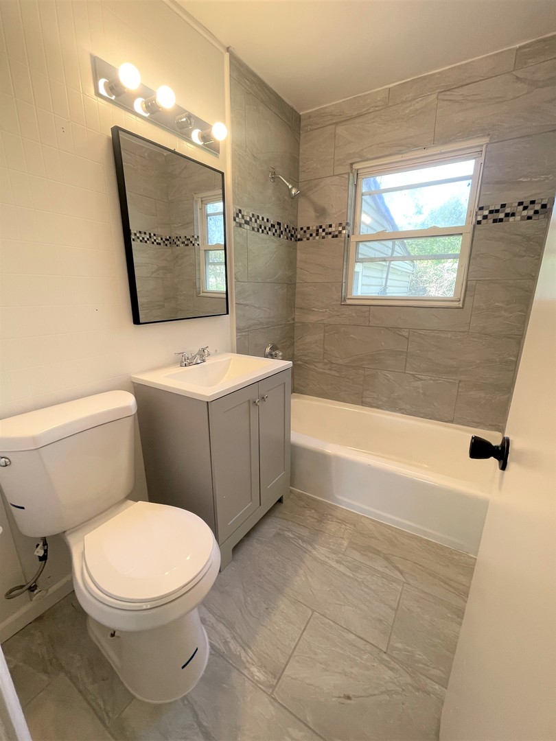 1119 New Lenox Road Joliet, IL 60433 - Photo 6 of 10 a bathroom with a toilet sink and mirror