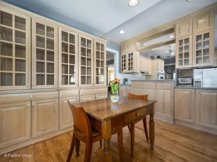 a kitchen with a table chairs and wooden floor