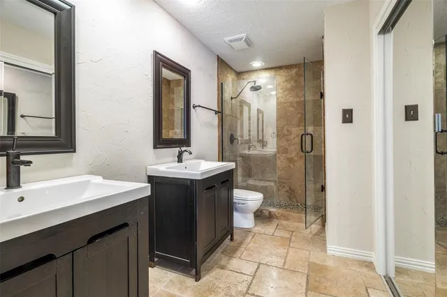 a bathroom with a double vanity sink toilet and shower