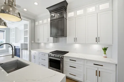 a kitchen with granite countertop a sink stainless steel appliances and cabinets