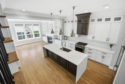 a kitchen with a sink stove and wooden floor