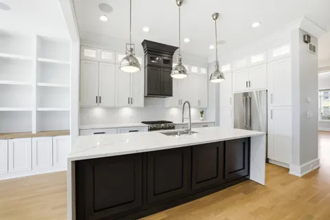 a kitchen with a sink a counter space appliances and cabinets
