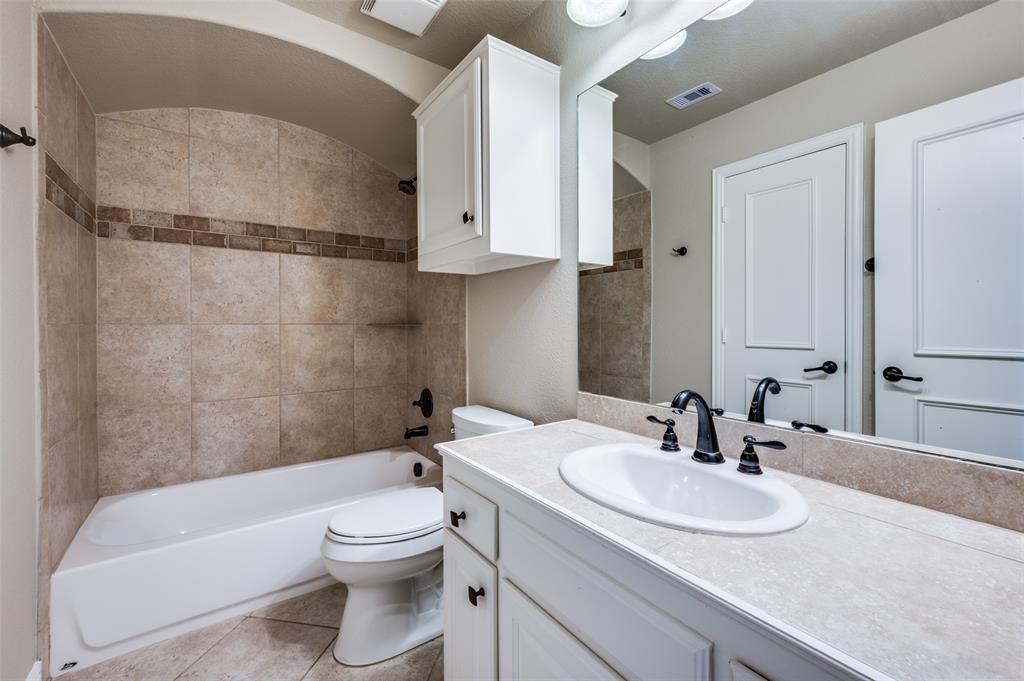 2168 Dampton Drive Frisco, TX 75033 - Photo 24 of 31 a bathroom with a granite countertop sink a toilet and bathtub