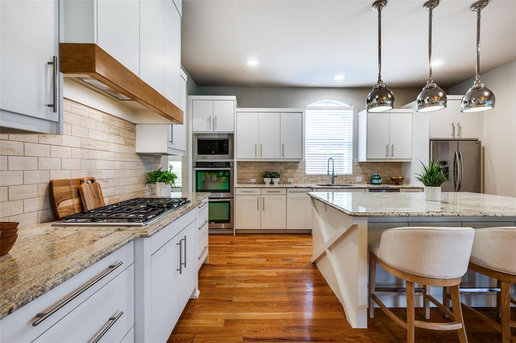 2168 Dampton Drive Frisco, TX 75033 - Photo 8 of 31 a kitchen with stainless steel appliances granite countertop a sink a stove and a wooden floors