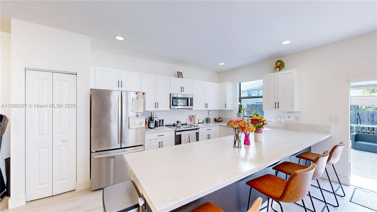 24902 Southwest 107th Avenue Homestead, FL 33032 - Photo 15 of 73 a kitchen with stainless steel appliances a refrigerator a stove a dining table and chairs