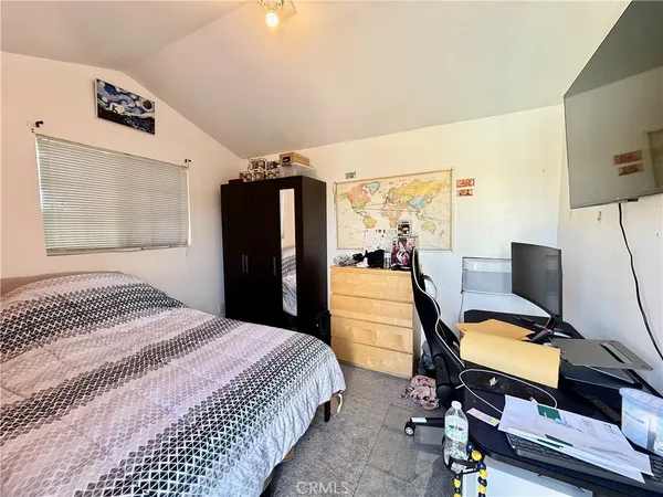 a bedroom with a bed flat screen tv and a couch