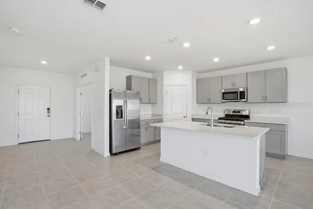 a kitchen with stainless steel appliances granite countertop a refrigerator oven a stove top oven a sink and dishwasher