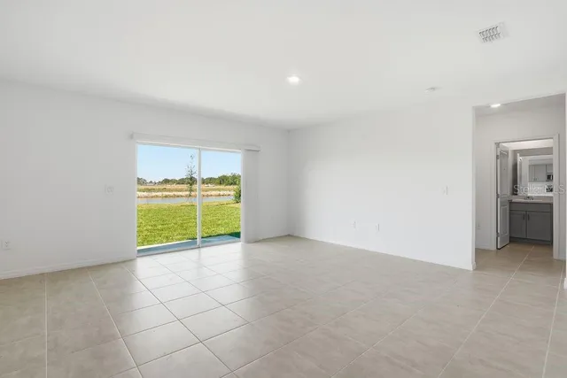 an empty room with a bathroom and a window