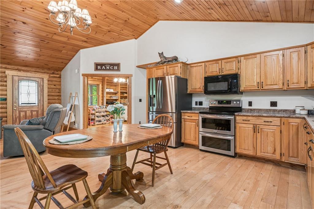 905 Indian Creek Valley Road Normalville, PA 15469 - Photo 14 of 38 a kitchen with stainless steel appliances a stove a sink dishwasher a refrigerator with a dining table and chairs