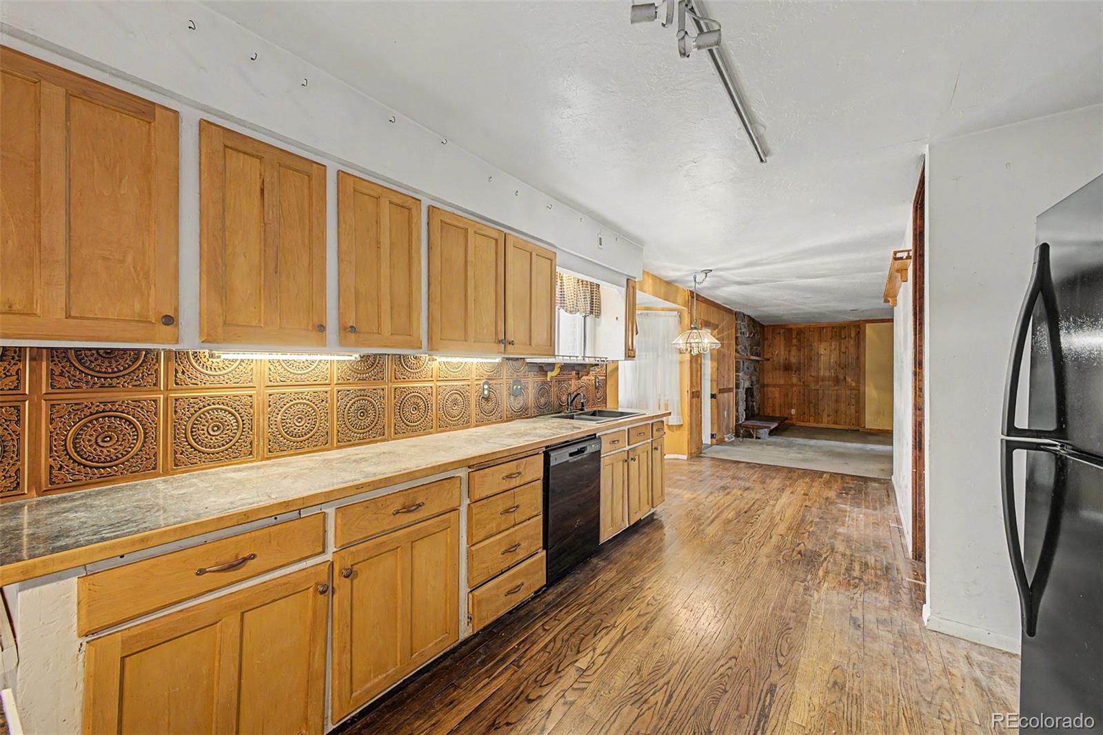 1600 Northwestern Road Longmont, CO 80503 - Photo 12 of 41 a kitchen with stainless steel appliances granite countertop a refrigerator a sink dishwasher a stove and white countertops with wooden floor