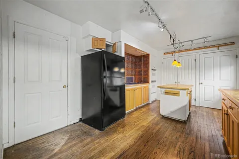 a kitchen with a refrigerator and white cabinets