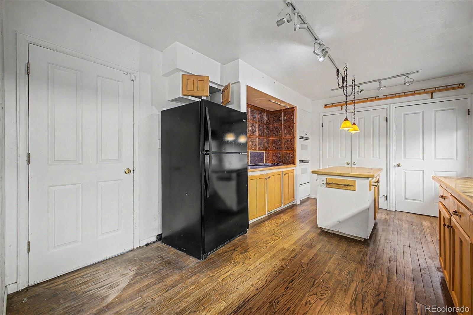 1600 Northwestern Road Longmont, CO 80503 - Photo 10 of 41 a kitchen with a refrigerator and white cabinets