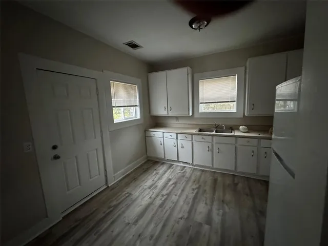 a kitchen with sink window and cabinets