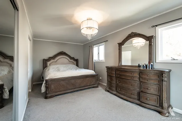 a bedroom with a bed and a large mirror on the dresser