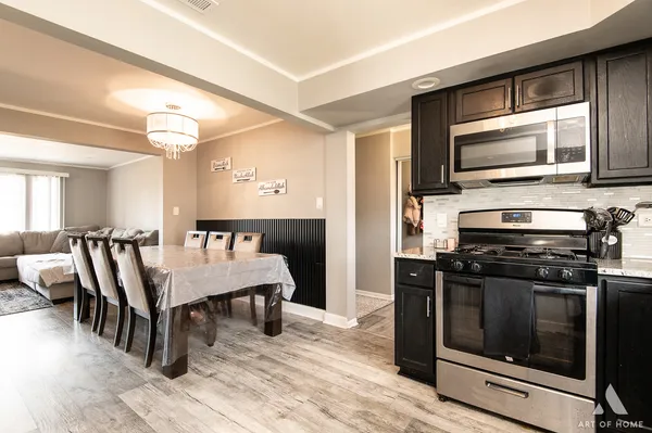 a kitchen with a stove a microwave and wooden floor