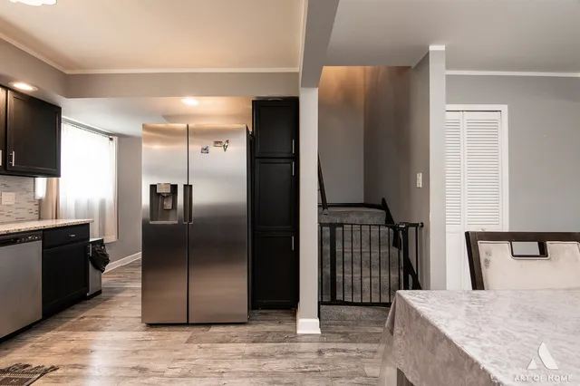 a kitchen with stainless steel appliances granite countertop a refrigerator and a sink
