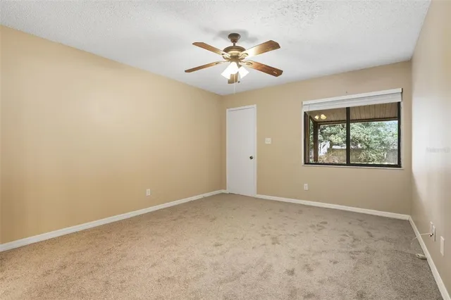 an empty room with fan and windows