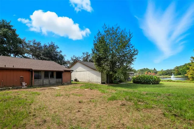 a view of a house with yard and tree s