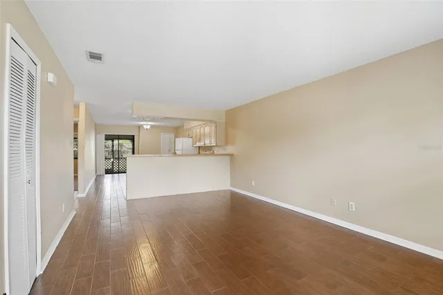 a view of a kitchen with wooden floor and a window