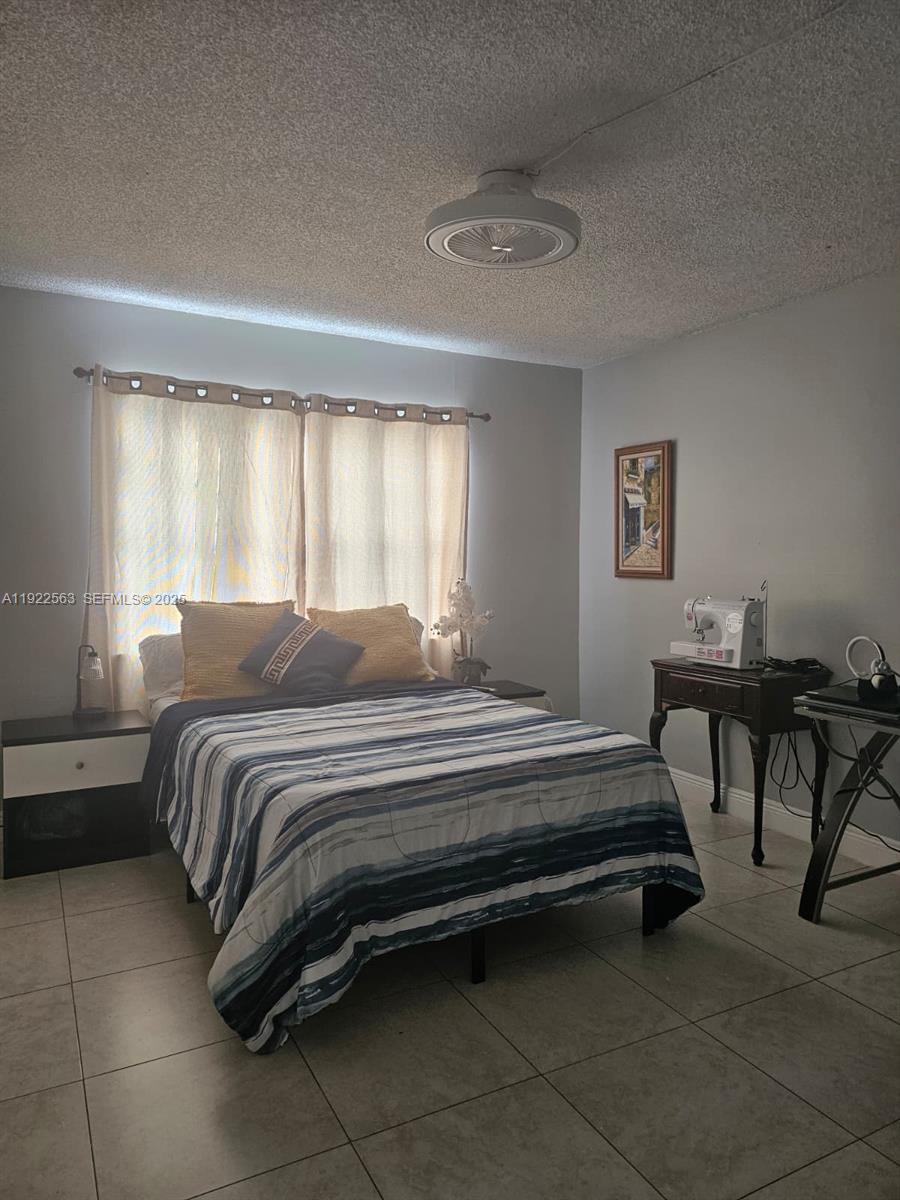 8411 Northwest 8th Street, Unit 111 Miami, FL 33126 - Photo 14 of 27 a spacious bedroom with a bed and a table in it