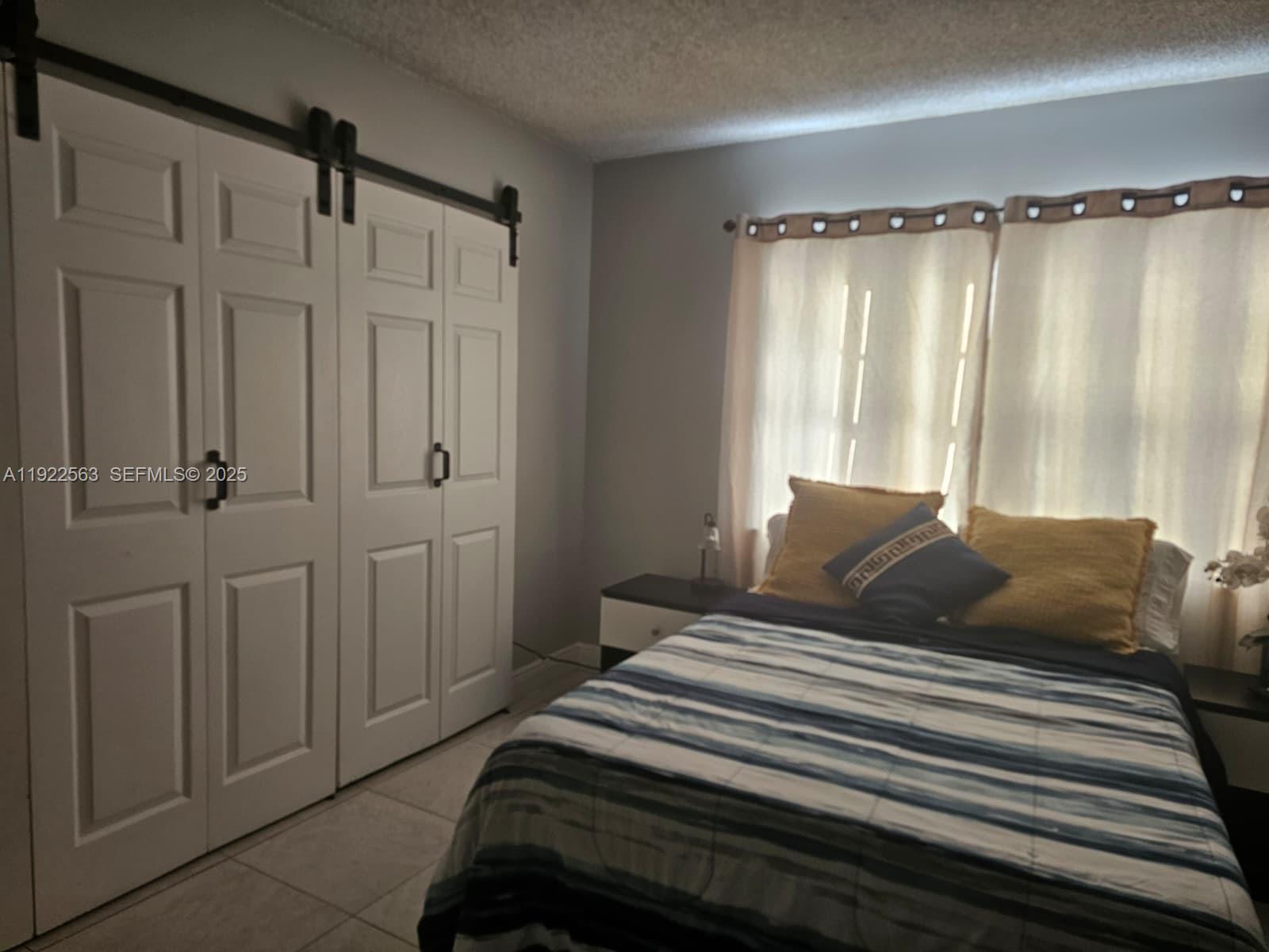 8411 Northwest 8th Street, Unit 111 Miami, FL 33126 - Photo 16 of 27 a bedroom with a bed and a window