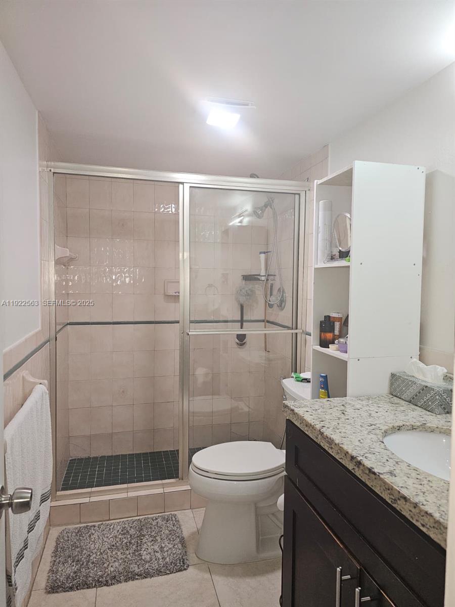 8411 Northwest 8th Street, Unit 111 Miami, FL 33126 - Photo 17 of 27 a bathroom with a granite countertop sink a toilet and shower