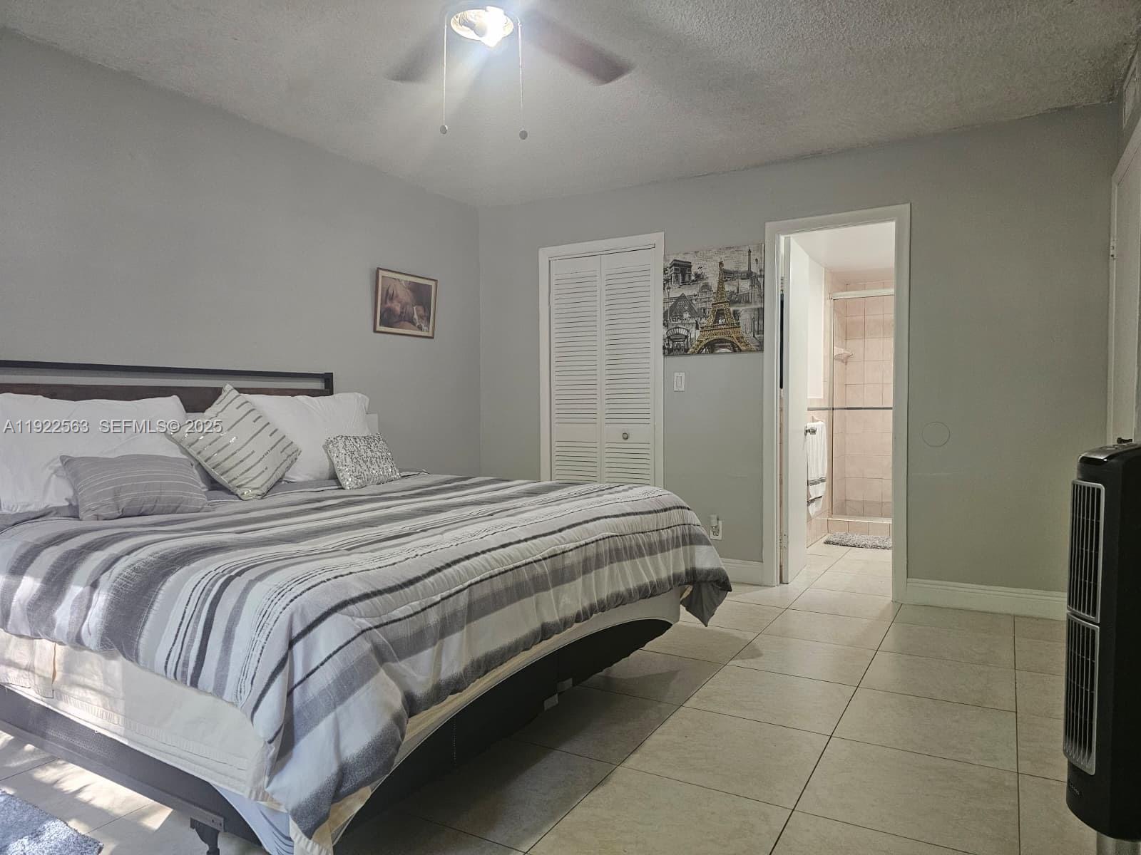 8411 Northwest 8th Street, Unit 111 Miami, FL 33126 - Photo 20 of 27 a bedroom with a bed and a refrigerator