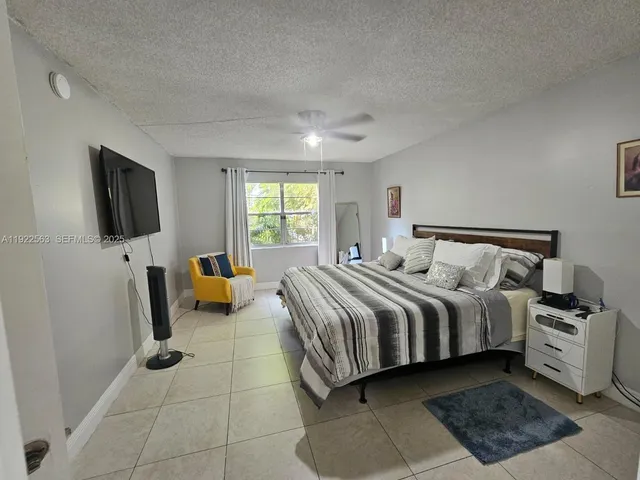 a spacious bedroom with a bed and a flat screen television