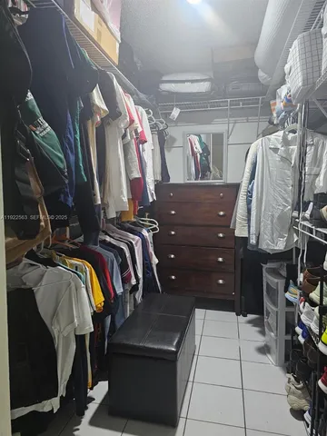 a view of walk in closet with clothes and shoes