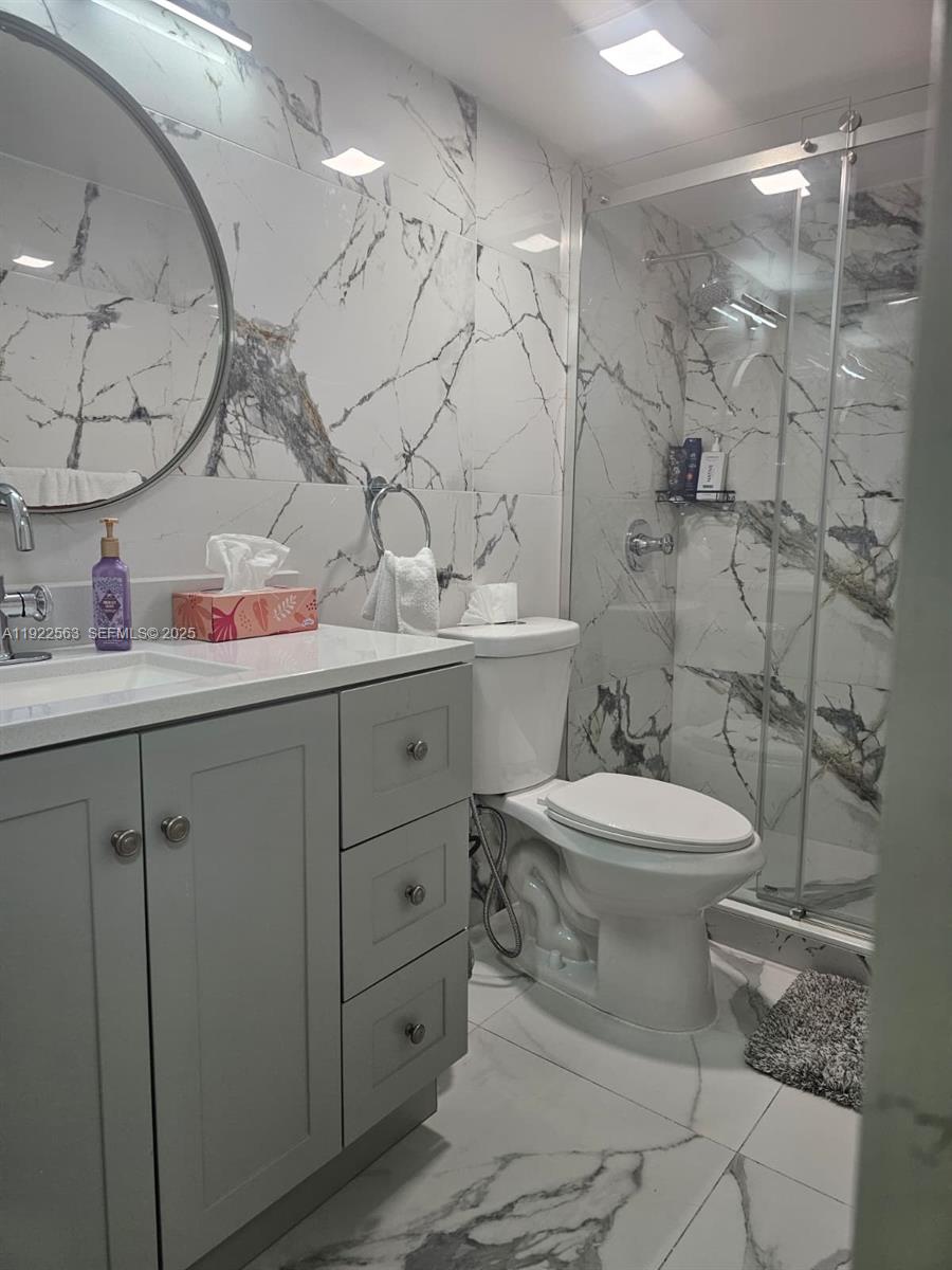 8411 Northwest 8th Street, Unit 111 Miami, FL 33126 - Photo 23 of 27 a bathroom with a toilet sink vanity granite and mirror