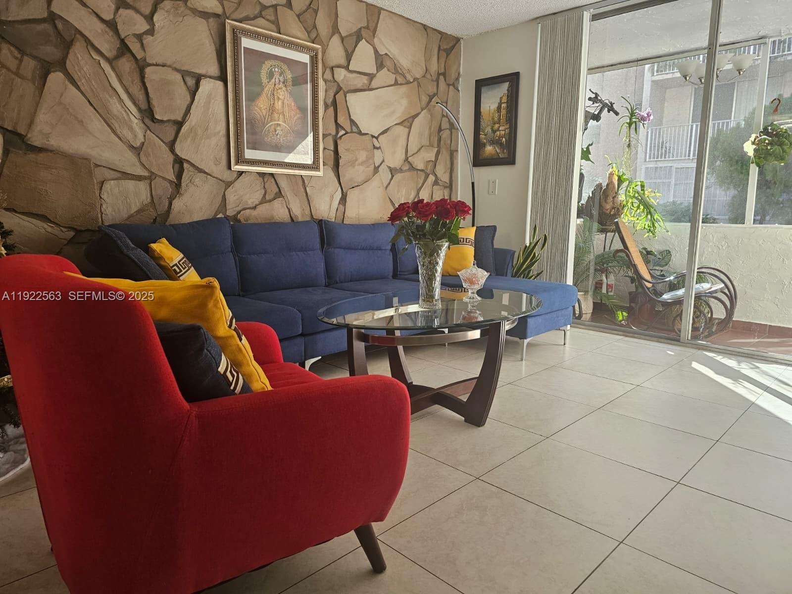 8411 Northwest 8th Street, Unit 111 Miami, FL 33126 - Photo 5 of 27 a living room with furniture a rug and white walls