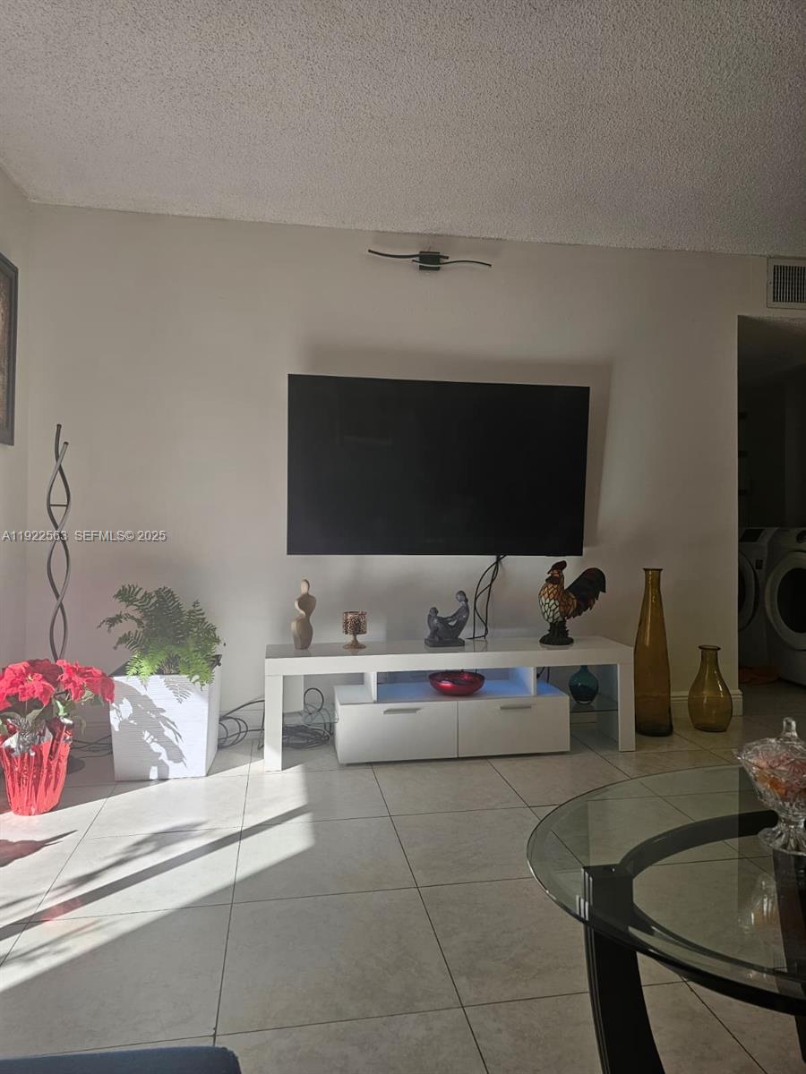 8411 Northwest 8th Street, Unit 111 Miami, FL 33126 - Photo 8 of 27 a living room with furniture and a flat screen tv