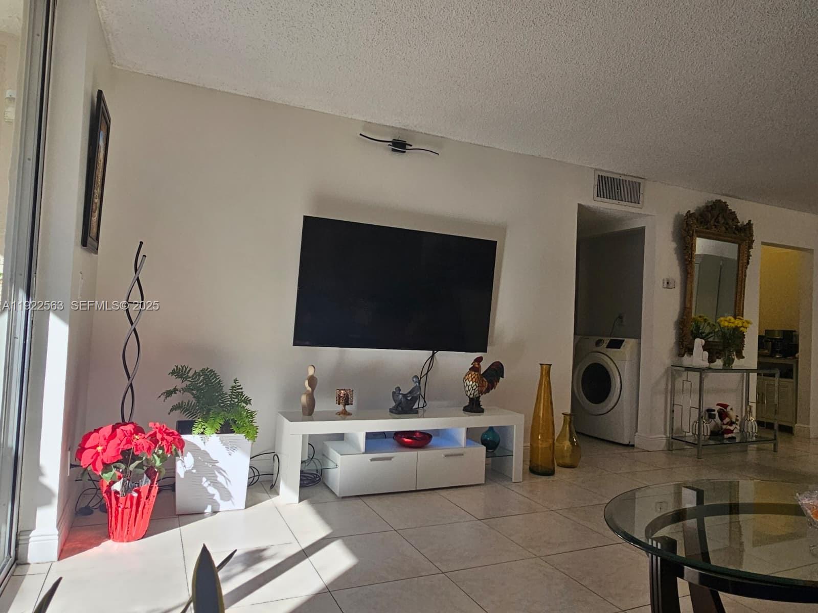 8411 Northwest 8th Street, Unit 111 Miami, FL 33126 - Photo 9 of 27 a living room with furniture and a flat screen tv
