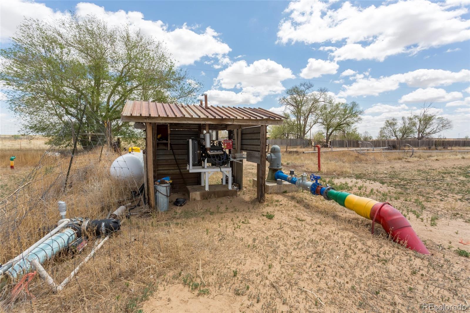 21550 Hanover Road Colorado Springs, CO 80928 - Photo 17 of 29 a view of a patio with table and chairs under an umbrella