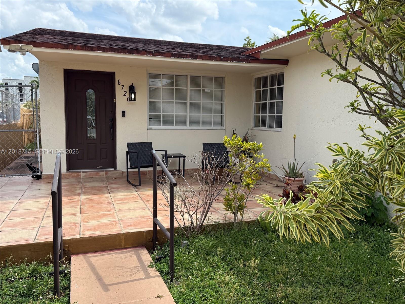 6720 Southwest 21st Street, Unit 1 Miami, FL 33155 - Photo 1 of 26 a front view of a house with garden
