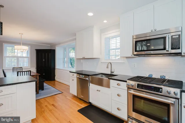 a kitchen with stainless steel appliances granite countertop a sink a stove and a refrigerator