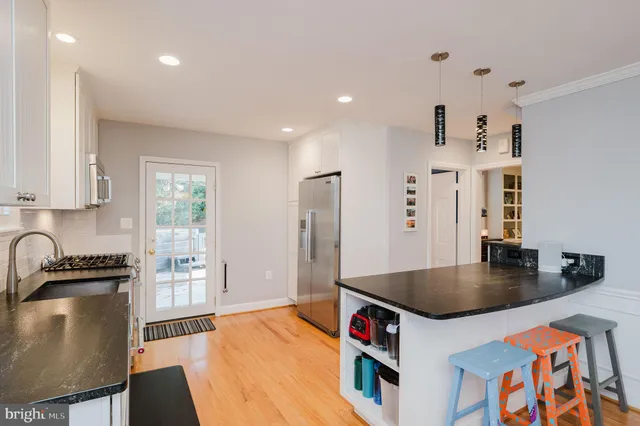 a kitchen with granite countertop a stove a sink and a refrigerator