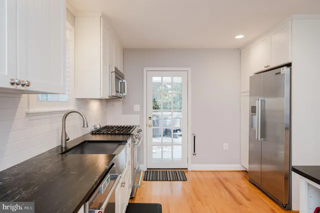 a dining room with furniture a chandelier and wooden floor