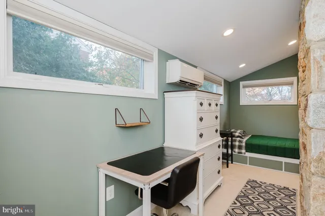 a room with furniture a clock on wall and a window