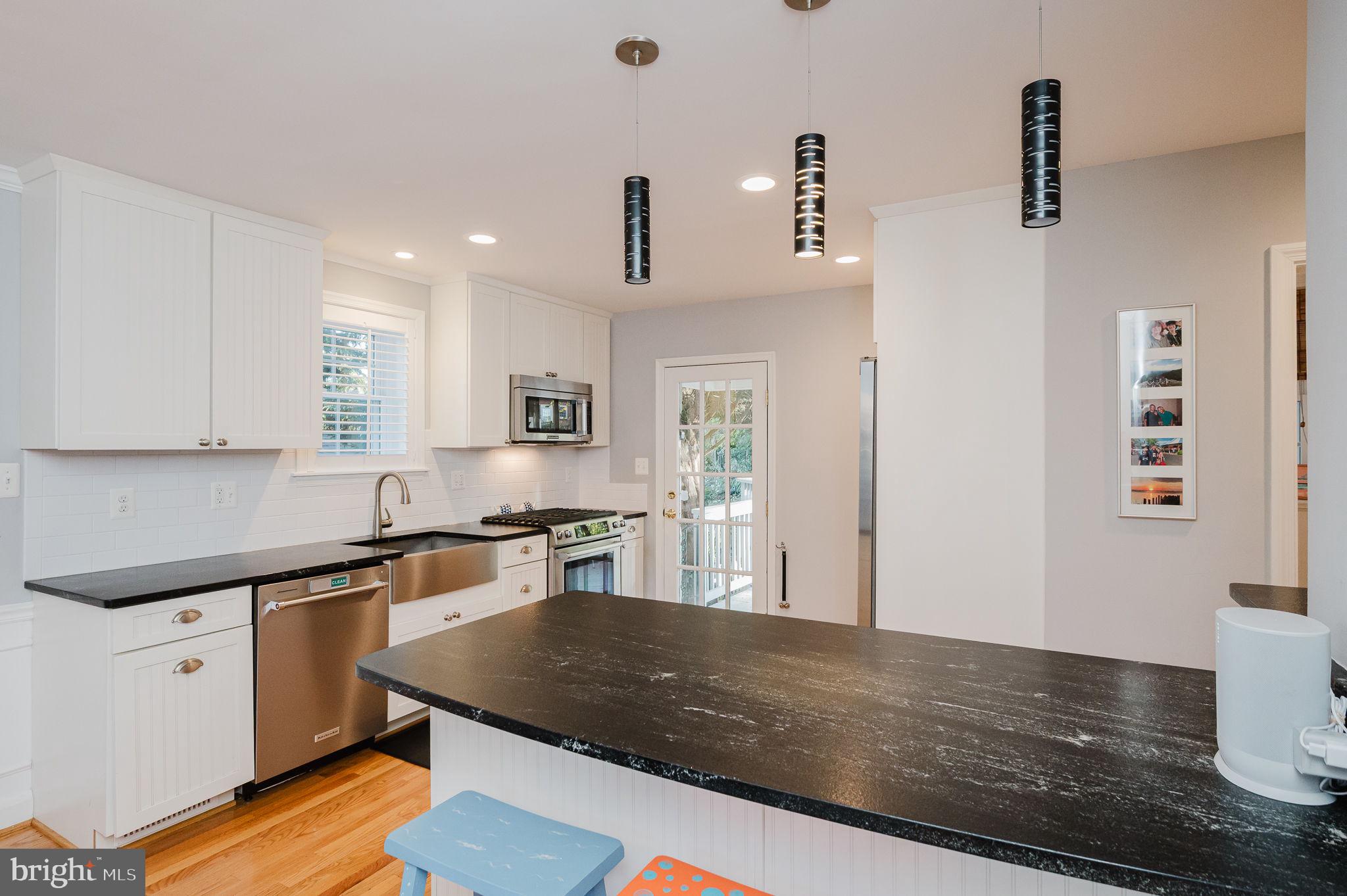 625 Yarmouth Road Towson, MD 21286 - Photo 7 of 69 a kitchen with stainless steel appliances granite countertop a sink dishwasher stove and white countertops with wooden floor