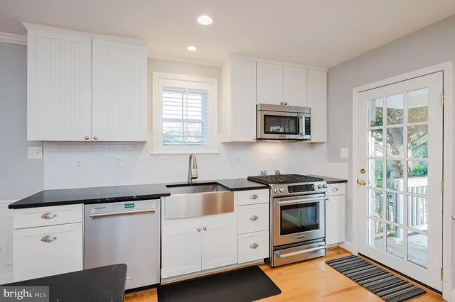 a kitchen with stainless steel appliances granite countertop a stove microwave and cabinets