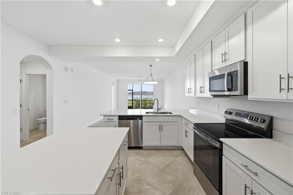 5555 Double Eagle Circle, Unit 3915 Ave Maria, FL 34142 - Photo 12 of 33 a kitchen with a sink stove top oven and cabinets