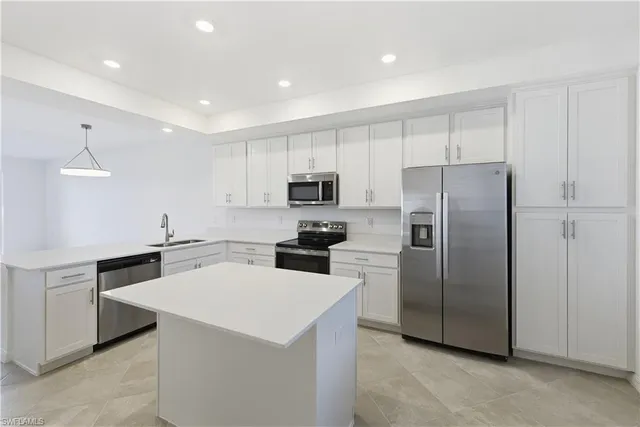 a kitchen with a sink a refrigerator and white cabinets