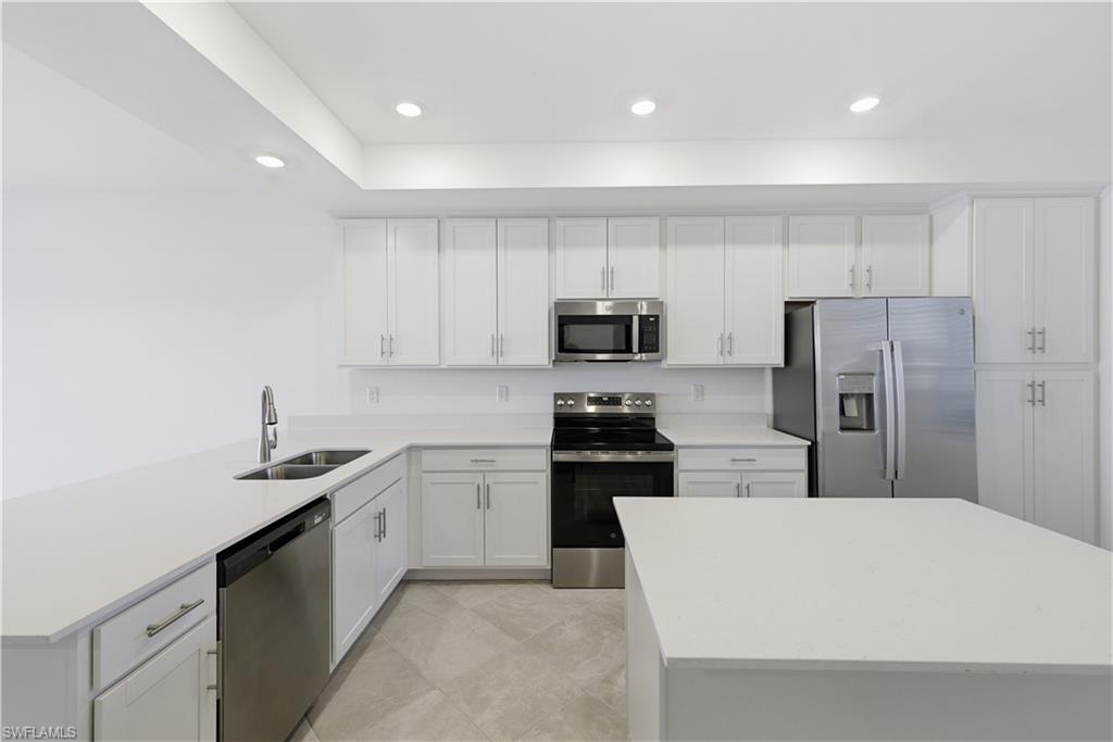 5555 Double Eagle Circle, Unit 3915 Ave Maria, FL 34142 - Photo 15 of 33 a kitchen with a sink a refrigerator and white cabinets